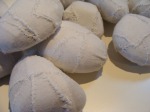 Pebbles covered in white cotton fabric, stitched seams